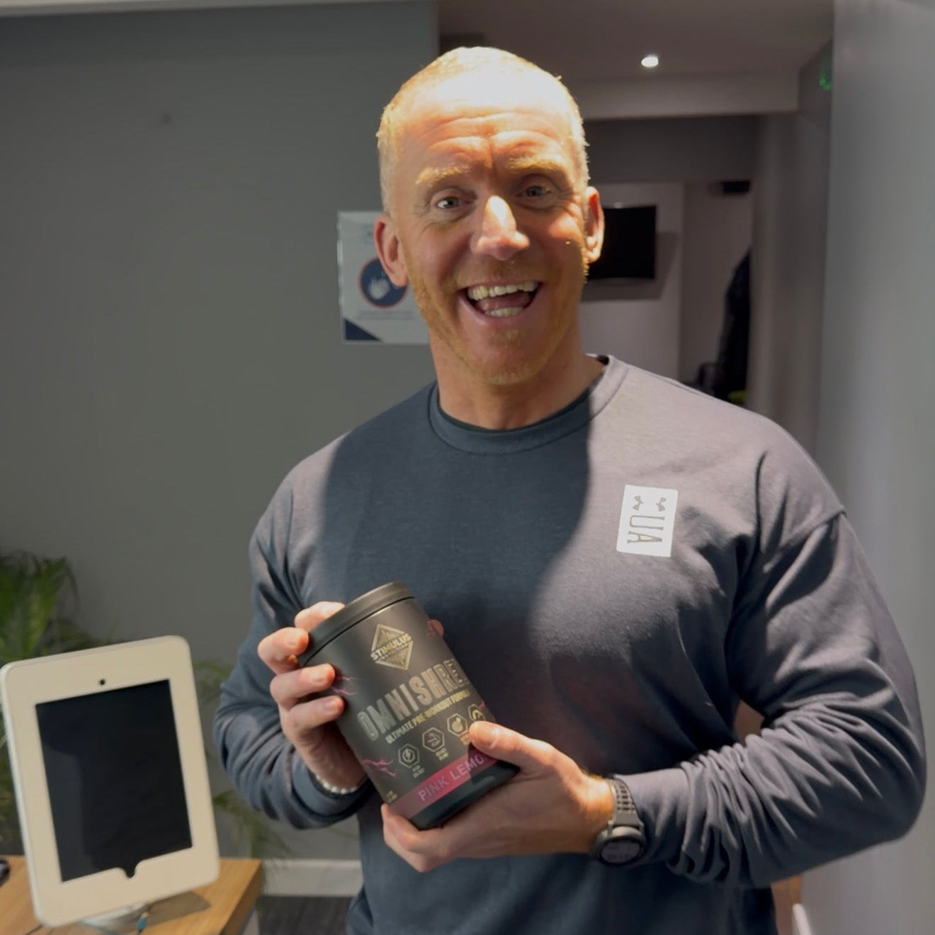Customer in workout gear holding the OMNISHRED tub, smiling